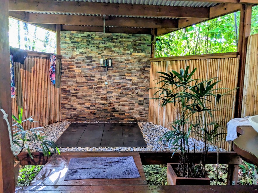 Bathhouse Weeroona Bungalow Airbnb Diddillibah on the Sunshine Coast. Tropical semi enclosed bathhouse with brick, timber, tin,bamboo walls and plants.